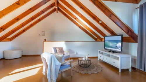 a living room with a tv and a chair at Bali Huts Escape in Nowra