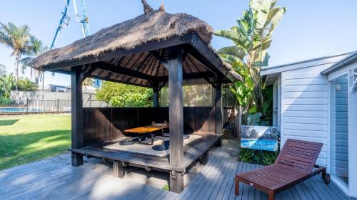 a gazebo with a table and a chair on a deck at Bali Huts Escape in Nowra