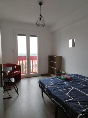 une chambre avec un lit, une chaise et des fenêtres dans l'établissement Les CHAMBRES de PERPIGNAN, à Perpignan