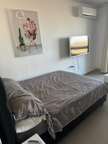 a bedroom with a bed and a flat screen tv at Mandarin beach in Jlil