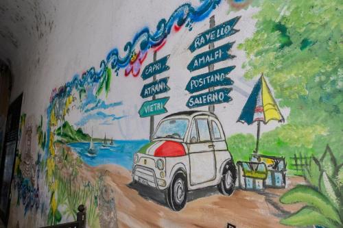 a painting of a car on a wall with signs at B & B Boutique Epoca in Salerno