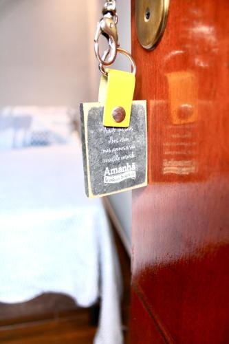 a padlock on a wooden door with a bed at Pousada Recanto Beach House - Cabo Frio - RJ- Unamar- Cond Florestinha - 1 min a pé da praia in Tamoios