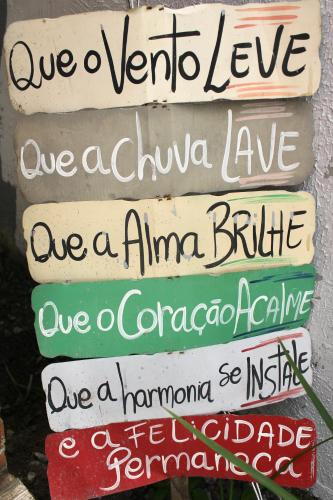 a group of different signs on a wall at Pousada Recanto Beach House - Cabo Frio - RJ- Unamar- Cond Florestinha - 1 min a pé da praia in Tamoios