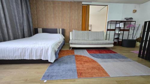 a bedroom with a bed and a chair and a rug at อิมแพ็ค เมืองทองธานี ห้องพักรายวัน Popular Condo T8 in Nonthaburi