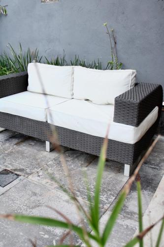 a black and white couch sitting on a patio at Pousada Recanto Beach House - Cabo Frio - RJ- Unamar- Cond Florestinha - 1 min a pé da praia in Tamoios