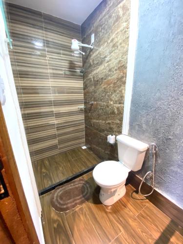 a bathroom with a toilet and a shower at Pousada Recanto Beach House - Cabo Frio - RJ- Unamar- Cond Florestinha - 1 min a pé da praia in Tamoios
