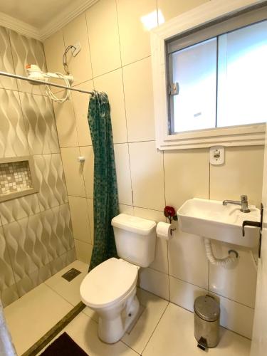 a bathroom with a toilet and a sink at Pousada Recanto Beach House - Cabo Frio - RJ- Unamar- Cond Florestinha - 1 min a pé da praia in Tamoios