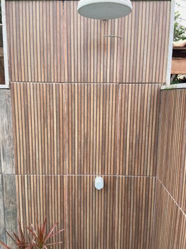 a wooden door with a light on top of it at Pousada Recanto Beach House - Cabo Frio - RJ- Unamar- Cond Florestinha - 1 min a pé da praia in Tamoios