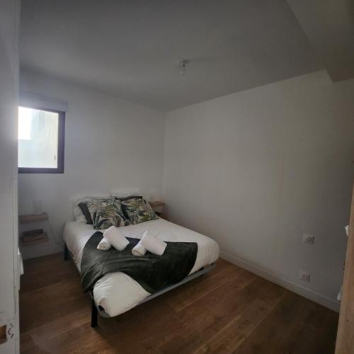 a bedroom with a bed with two towels on it at L'aT3lier d'Orthez in Orthez