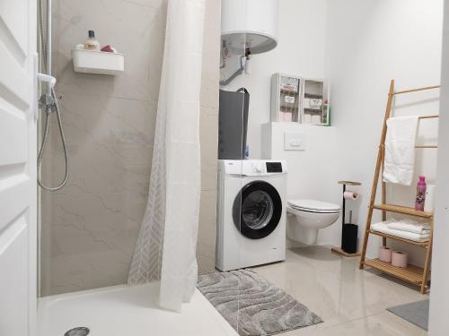 a bathroom with a washing machine and a toilet at L'aT3lier d'Orthez in Orthez