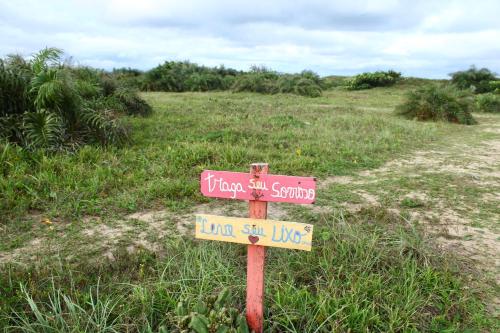a street sign in the middle of a dirt road at Pousada Recanto Beach House - Cabo Frio - RJ- Unamar- Cond Florestinha - 1 min a pé da praia in Tamoios