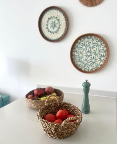 two baskets of fruit on a table with plates at Retreat block B1 unit16 in Küçükerenköy