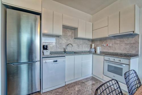 a kitchen with white cabinets and a stainless steel refrigerator at Retreat, block B1, unit7 in Küçükerenköy