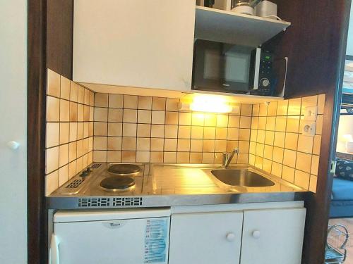 une petite cuisine avec un évier et un micro-ondes dans l'établissement Studio cosy à Plagne Centre avec accès direct aux pistes - FR-1-351-147, à La Plagne Tarentaise