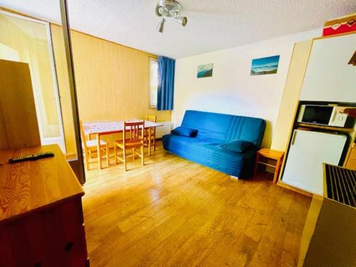 un salon avec un canapé bleu et une table dans l'établissement Charmant 2 pièces au pied des pistes, balcon sud/ouest, centre station - FR-1-516-88, à Les Deux Alpes