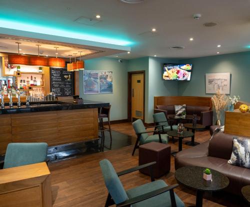 a bar in a restaurant with chairs and tables at Future Inn Plymouth in Plymouth