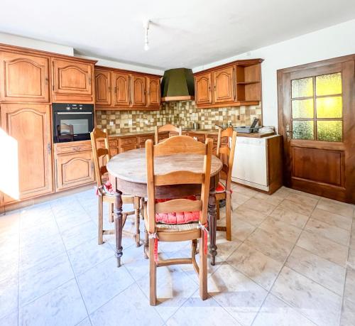a kitchen with wooden cabinets and a table and chairs at Central & quiet, Full apt for 8 Trésor caché in Colmar