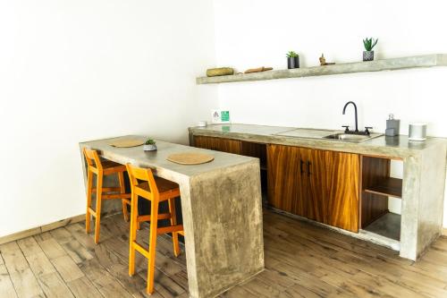 a kitchen with a sink and a table with chairs at Casa Teotl Puerto Escondido in Brisas de Zicatela