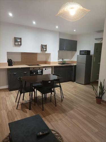 une cuisine avec une table et des chaises dans une pièce dans l'établissement Le nid, à Saint-Yrieix-la-Perche