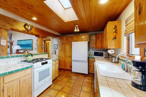a kitchen with wooden cabinets and a white refrigerator at Theodora Charmer in Taos