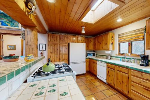 a kitchen with wooden cabinets and a stove top oven at Theodora Charmer in Taos