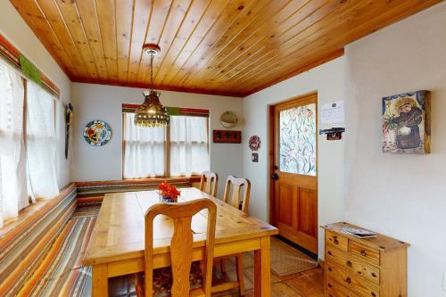 a dining room with a wooden table and a wooden ceiling at Theodora Charmer in Taos