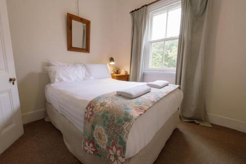 a bedroom with a bed with two towels on it at Larsens Cottage 1 - Historic 1880 Home in Mount Victoria