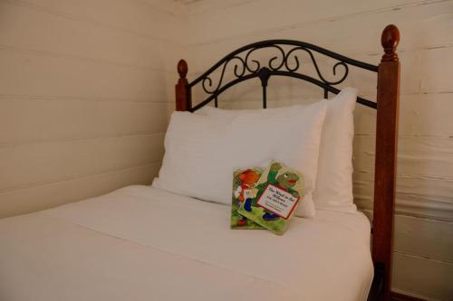 a bed with white sheets and a wooden head board at Larsens Cottage 1 - Historic 1880 Home in Mount Victoria