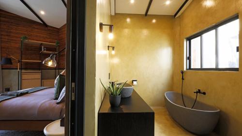 a bedroom with a bathroom with a tub and a bed at Qurtuba Hotel and Spa in Sandown