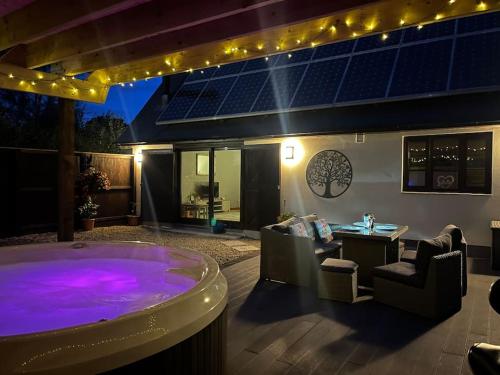 a backyard with a hot tub and a table and chairs at Ty Gardd - Luxury lodge with covered hot tub in Usk