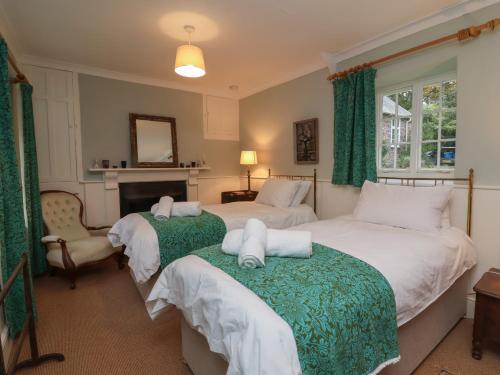 a bedroom with two beds and a fireplace at Laundry Cottage in Bideford