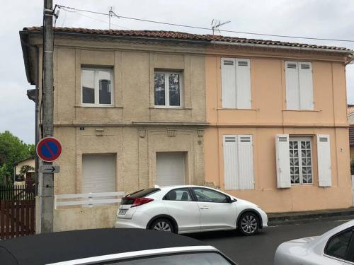 une voiture blanche garée devant une maison dans l'établissement appartement la teste centre, à La Teste-de-Buch