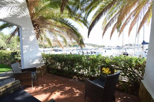 a patio with chairs and a view of a marina at Villa Sul Porto in Porto Ottiolu