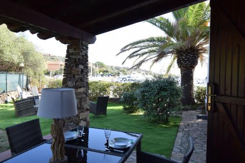 a table with a lamp on a patio with a palm tree at Villa Sul Porto in Porto Ottiolu