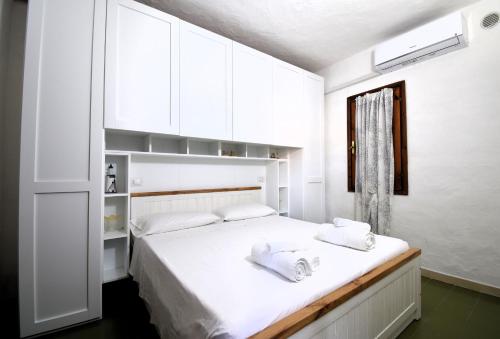 a white bedroom with a bed with white cabinets at Villa Sul Porto in Porto Ottiolu