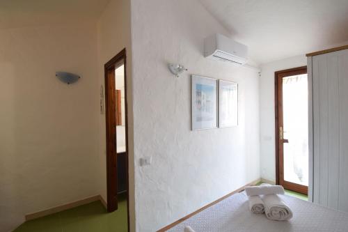 a white room with a bed with two towels on it at Villa Sul Porto in Porto Ottiolu