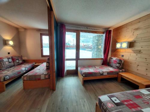 une chambre avec deux lits et une fenêtre dans l'établissement Studio divisible cosy, 4 pers, skis aux pieds - FR-1-353-128, à La Plagne Tarentaise