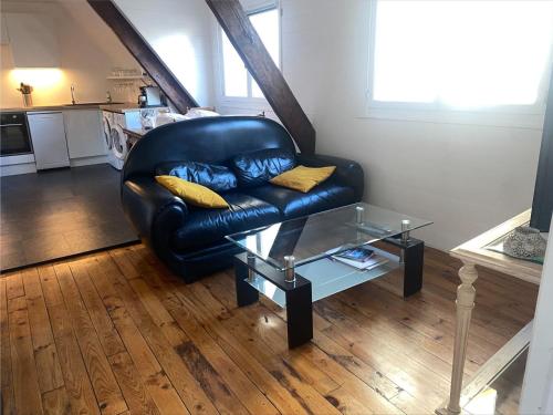 - un canapé en cuir noir dans un salon avec une table dans l'établissement Appartement rénové au centre du Palais, proche plage et commodités - FR-1-418-226, au Palais