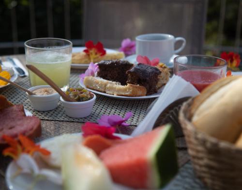 a table topped with plates of food and drinks at Pousada Casa Rosa in Alto Paraíso de Goiás