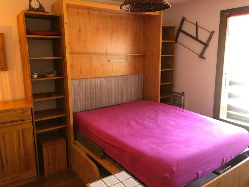 une chambre avec un lit avec un couvre-lit rose dans l'établissement Studio cabine ski et rando, 4 pers, pied des pistes, Arêches-Beaufort - FR-1-342-313, à Beaufort