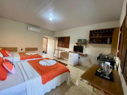 a hotel room with a large bed and a desk at FLAT 228 - Hotel Pedra do Rodeadouro-Bonito-PE in Bonito