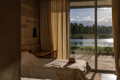 a bedroom with a bed and a view of a lake at Lodge Tunuyan, Destino Uconia in Vista Flores