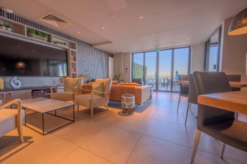 a living room filled with furniture and a large screen tv at Polzeath Beach House in Polzeath