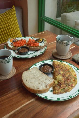 uma mesa com dois pratos de comida e duas xícaras de café em Kuka y Milpa em Mérida