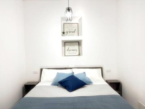 a bedroom with a bed with two pictures on the wall at San Giovanni Apartment in Catanzaro