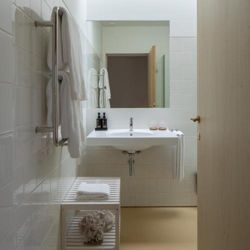 a white bathroom with a sink and a mirror at Quinta do Outeiro 1598 in Ponte da Barca