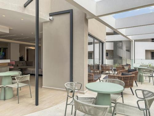 a lobby with tables and chairs and a cafeteria at Mare Village Hotel in Georgioupolis