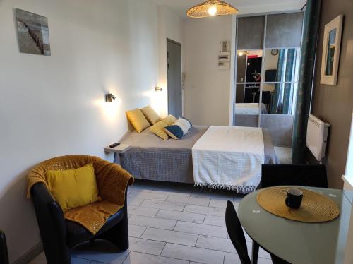 une chambre avec un lit, une table et des chaises dans l'établissement SCI les THERMES 17, à Rochefort