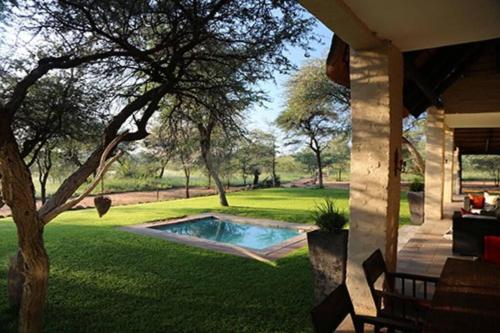a house with a swimming pool in a yard at Farm stay in the heart of the Kalahari Namibia- serviced luxury self catering accommodation in Gobabis