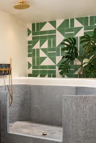 a bathtub with a green and white wall at Porto Mykonos in Mýkonos City